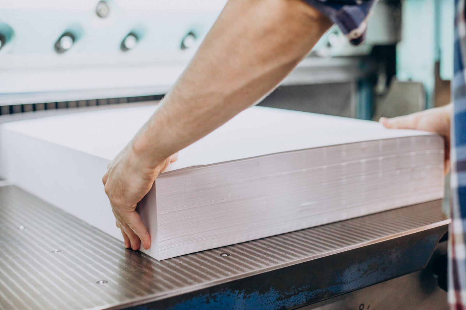 man working in printing house with paper and paints
